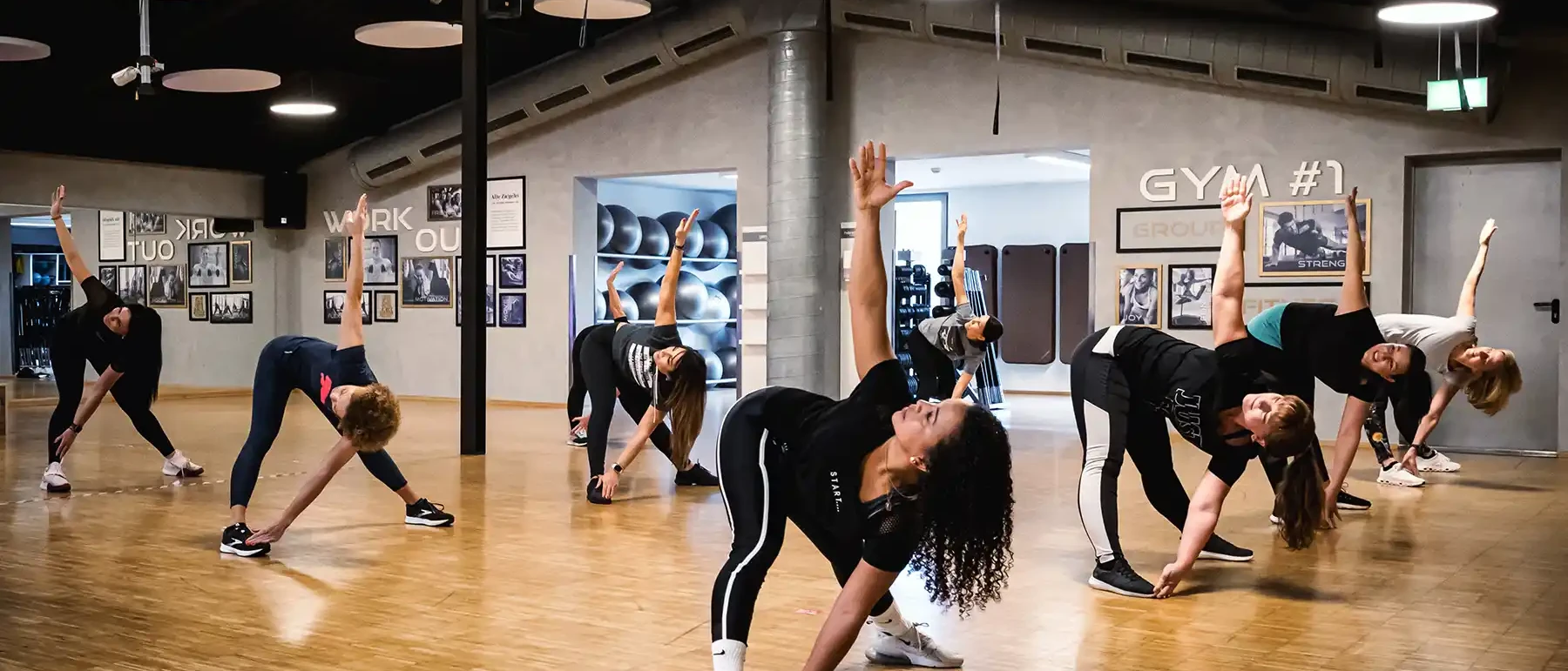 Gruppe im Bewegungskurs beim seitlichen Dehnen im Kursraum des Sport+WellnessPark ALTE ZIEGELEI