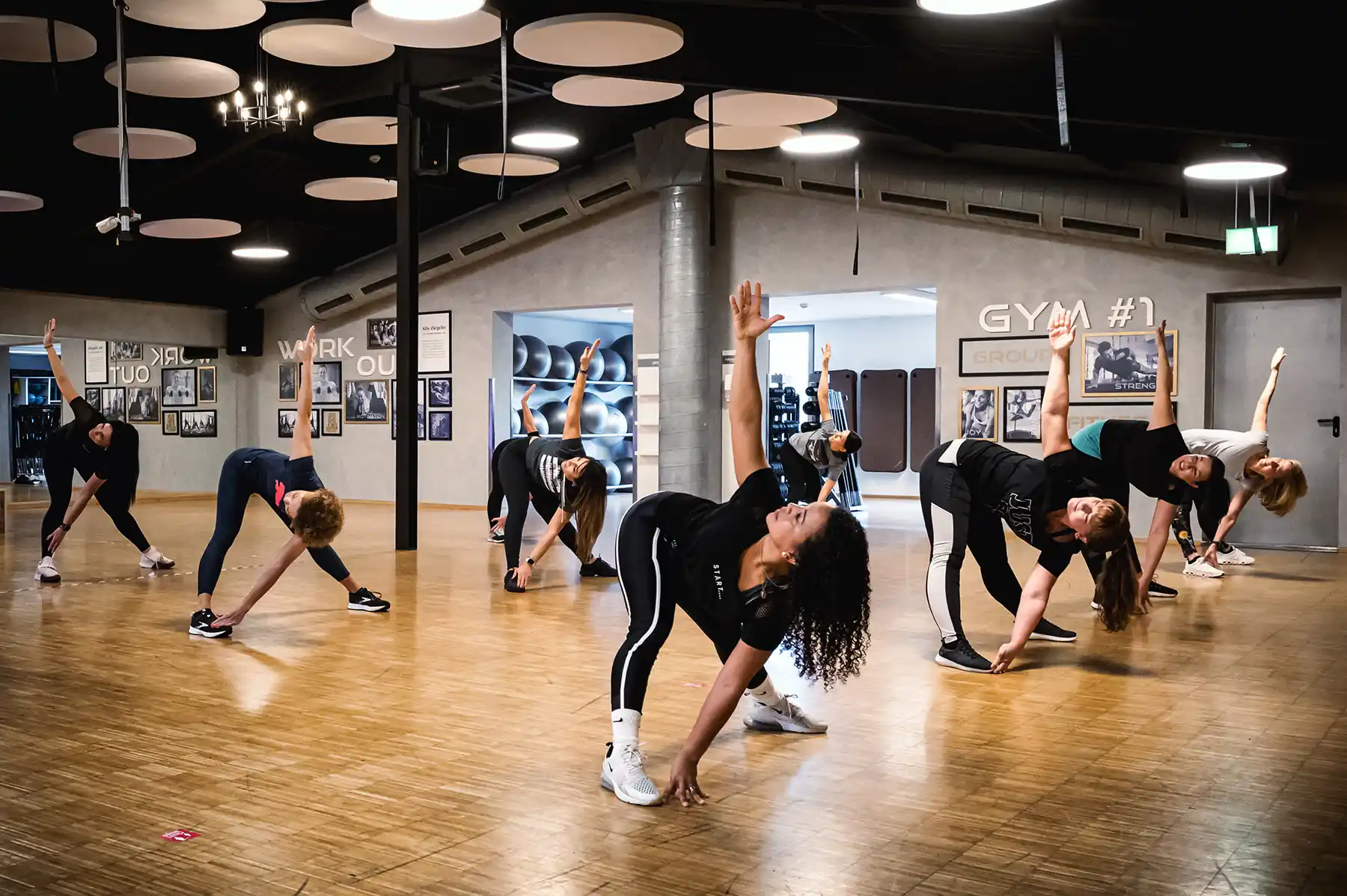 Gruppe im Bewegungskurs beim seitlichen Dehnen im Kursraum des Sport+WellnessPark ALTE ZIEGELEI